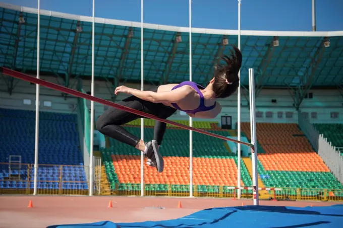 Sportswoman doing high jump exercise