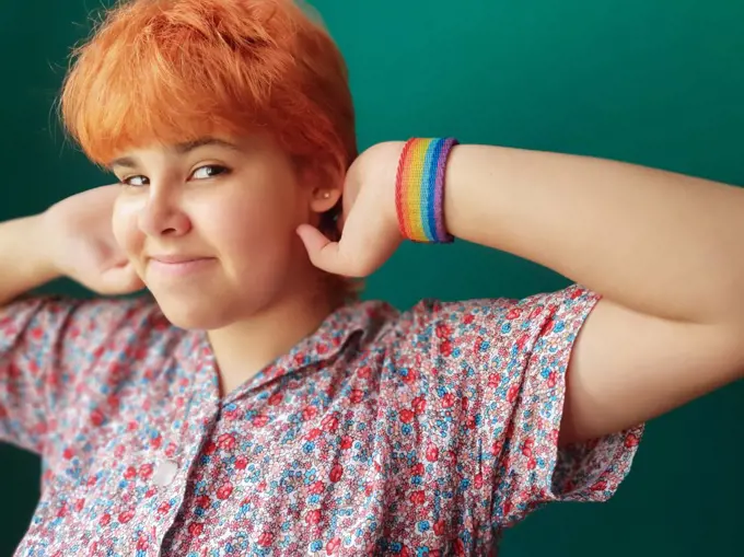 Red hair teenager girl with a LGTB bracelet looking at camera proudly