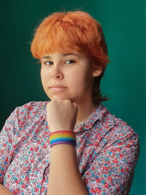 Red hair teenager girl with a LGTB bracelet looking at camera proudly