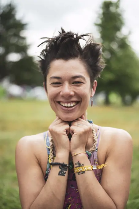 Smiling mixed-race asian woman with fun hair at festival in Poland