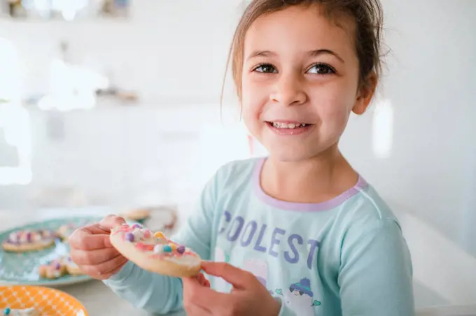 Young girl smiling with decorated easter cookie