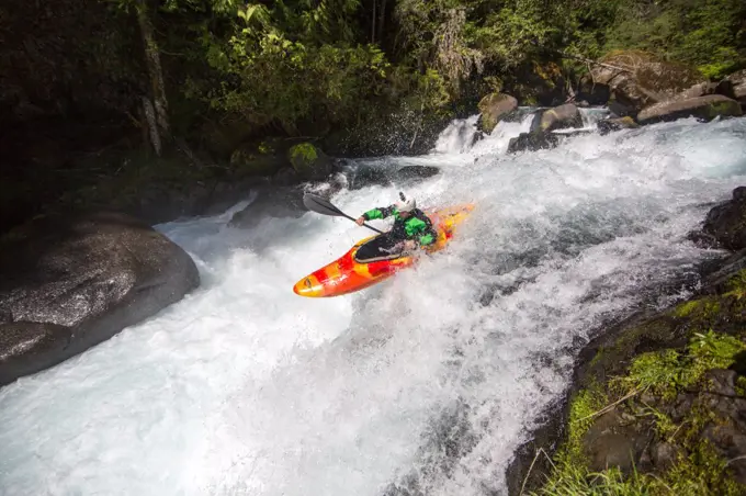 Whitewater kayaking off a small waterfall