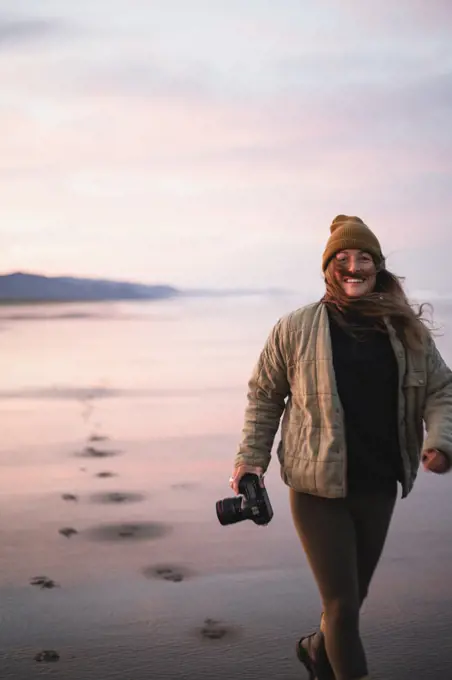 Smiling Young Female Photographer on Oregon beach at sunrise