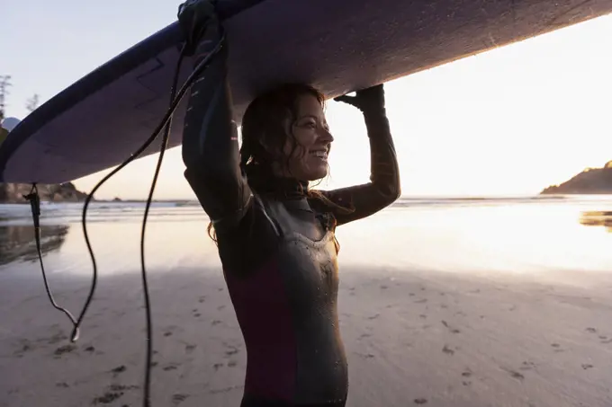 Woman carrying surfboard on head at Short Sands, Oregon