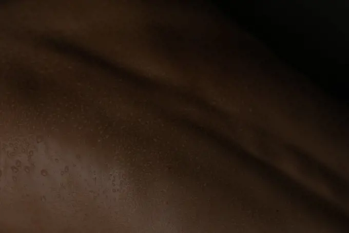 Close up of water on spine and back of woman skin