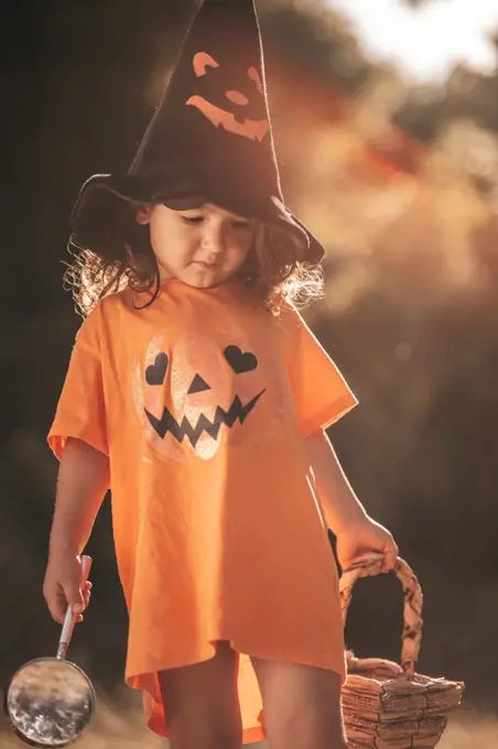 little girl celebrate Halloween in nature pumpkin
