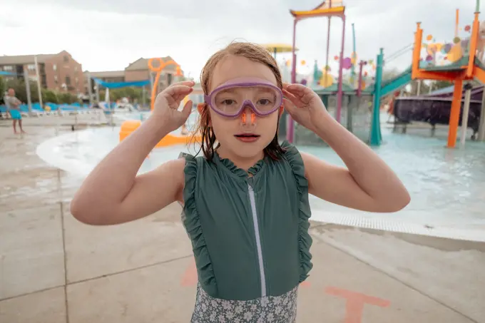 Young girl with goggles and nose plug at water park