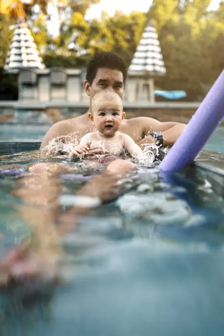 Dad holding baby in the pool