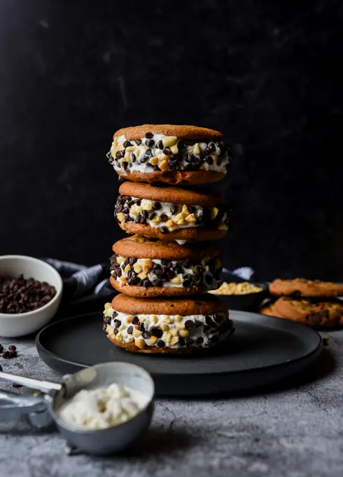 Stack of chocolate chip cookie ice cream sandwiches on a plate.