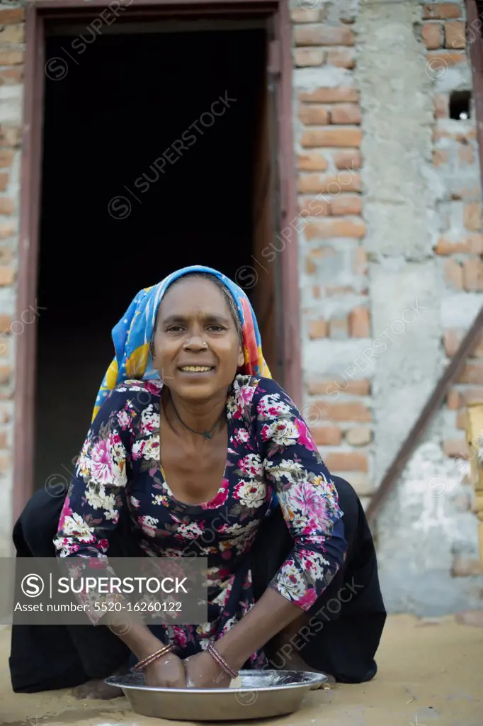 old woman kneading dough, Rural India
