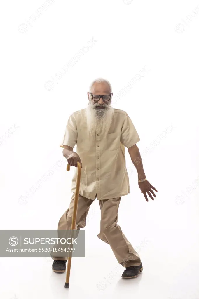 A HAPPY OLD MAN PLAYFULLLY DANCING USING STICK