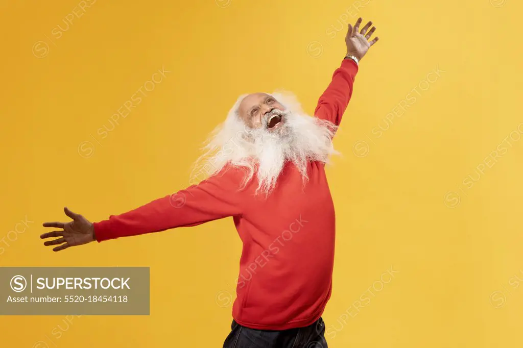 A CHEERFUL OLD MAN HAPPILY RAISING ARMS AND LOOKING ABOVE