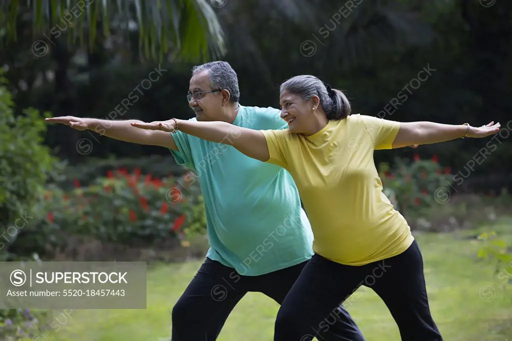 A HAPPY HUSBAND WIFE EXERCISING TOGETHER IN A PARK