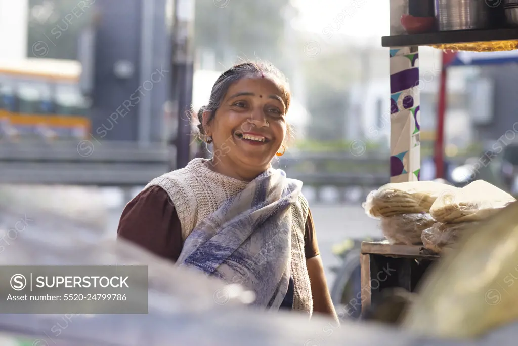 Portrait of a smiling female vendor at her roadside food stall