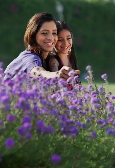 Mother and daughter plucking flowers
