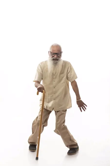 A HAPPY OLD MAN PLAYFULLLY DANCING USING STICK