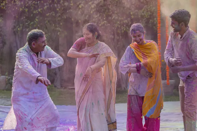 Happy Indian family dancing together on the occasion of Holi