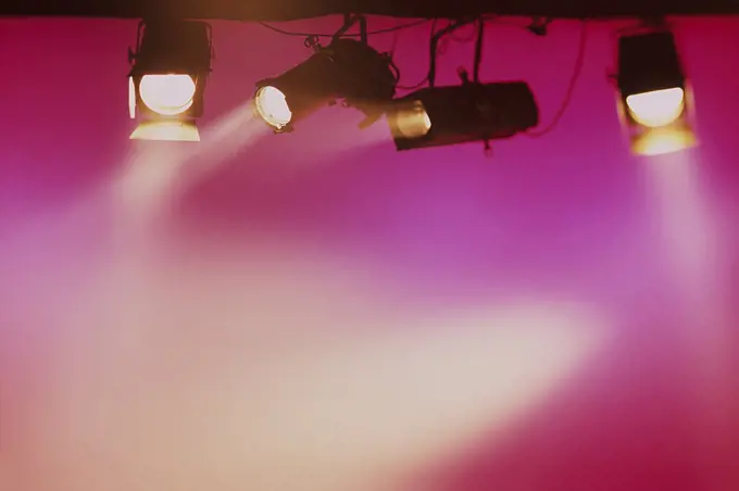 Stage lights shining golden light with pink background
