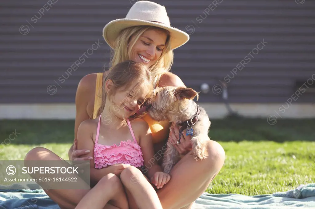 Dog stealing kisses from child on a summer day