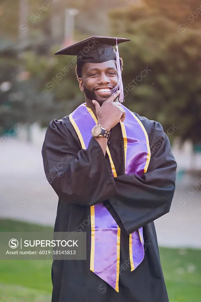 Man happy to be graduating college, wearing a graduation gown/cap