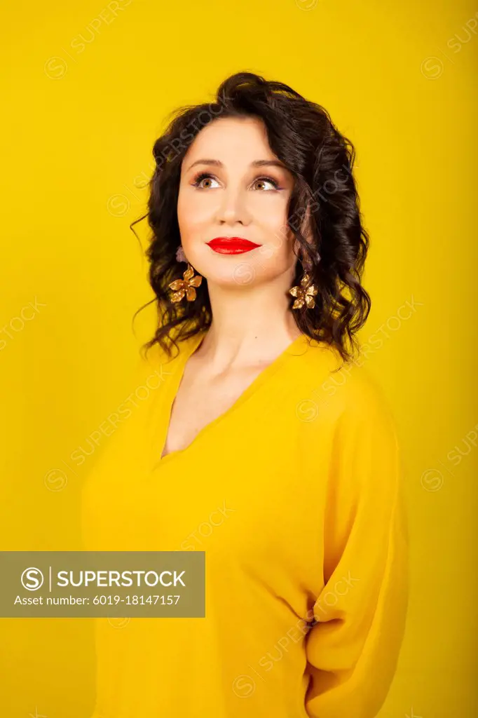 a young woman in a bright yellow jacket on a yellow background