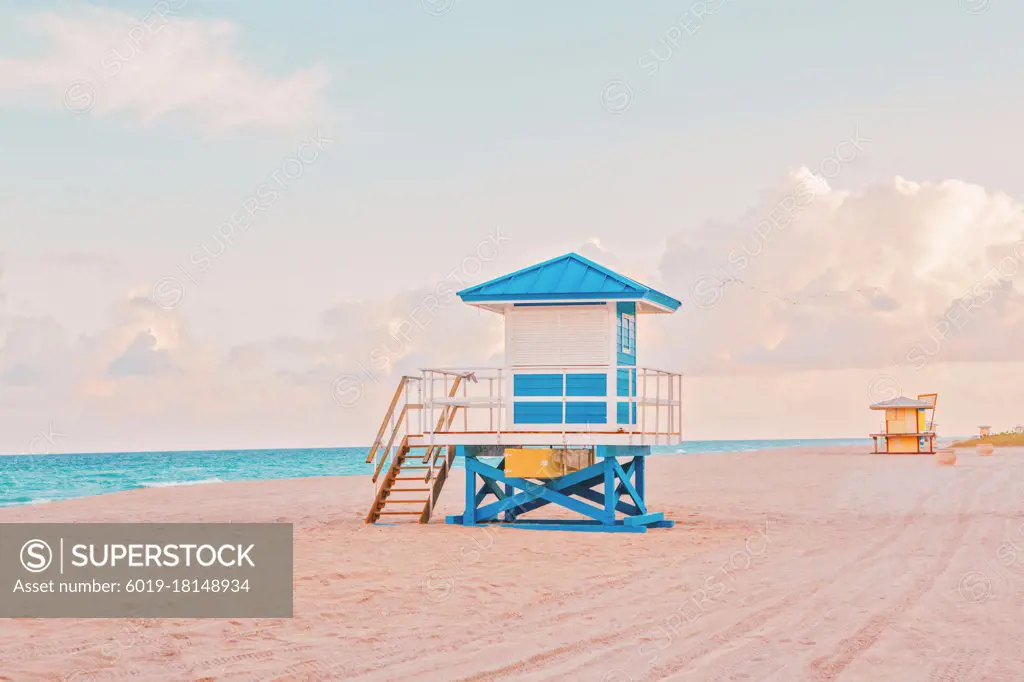 Empty Florida beach with lifeguard houses on sunset. Airy light nature