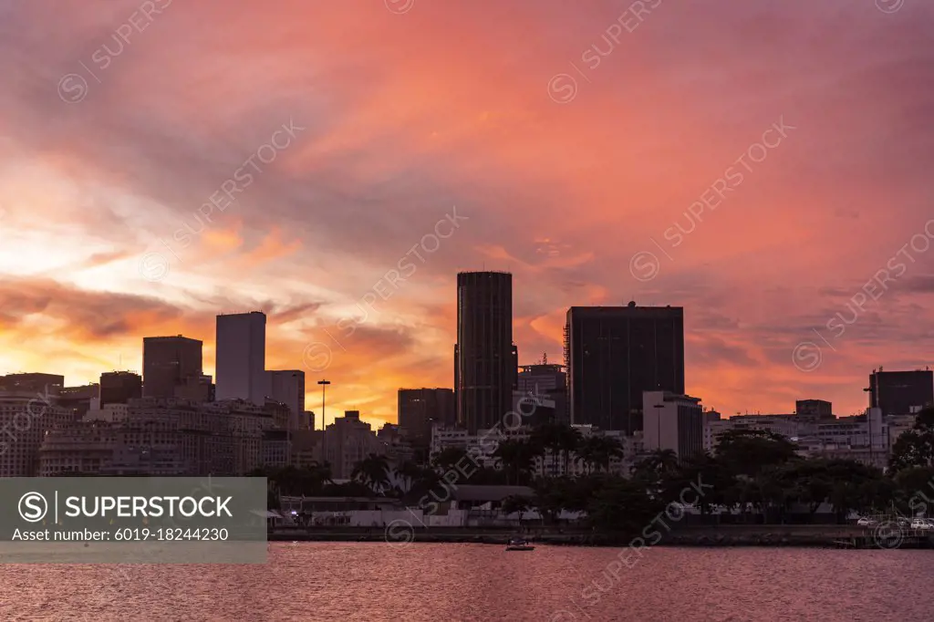 Beautiful sunset view to orange clouds over downtown buildings