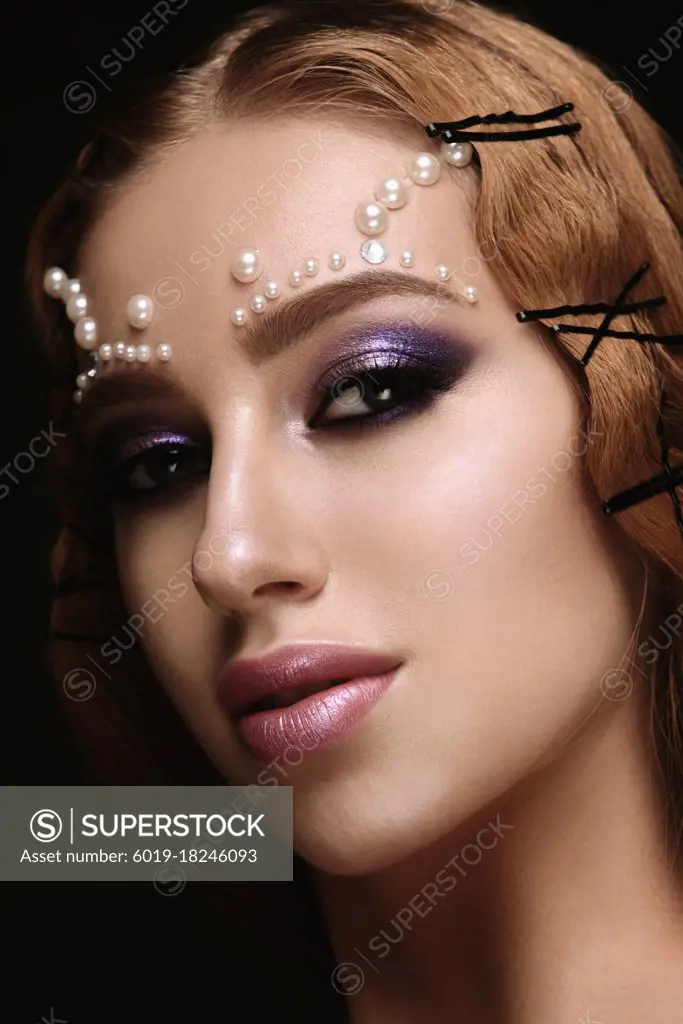 Beautiful woman portrait with art make up, pearl beads on face.