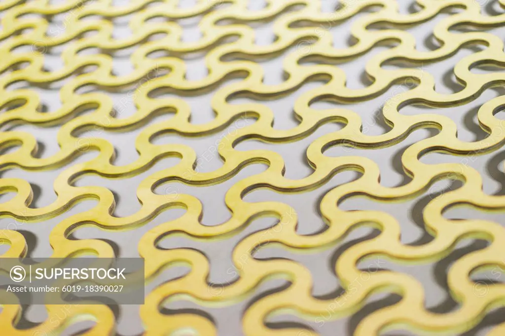 Abstract background, a repeating pattern of gold curved round cells in a gold lattice.