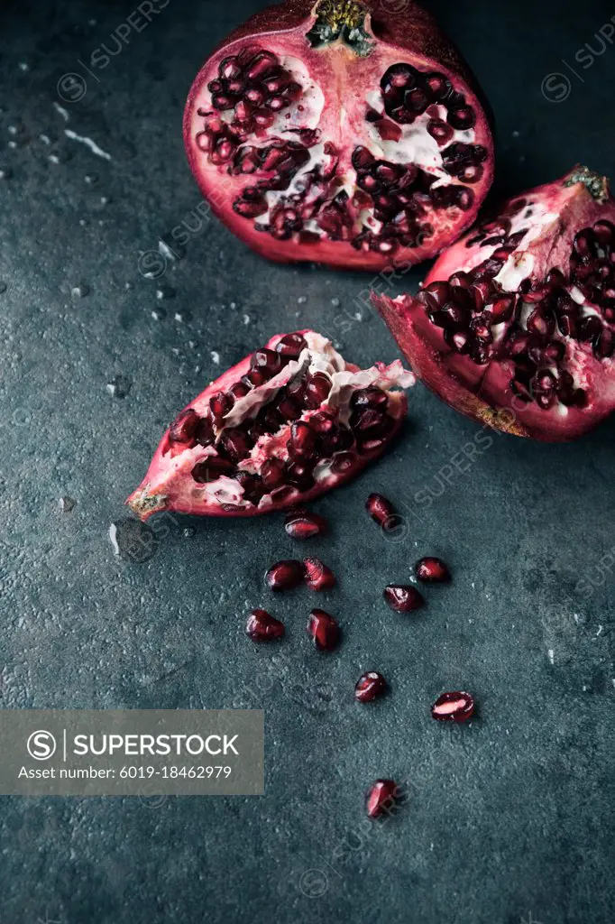 Red Ripe Pomegranate with Water Splashes on Black  Background