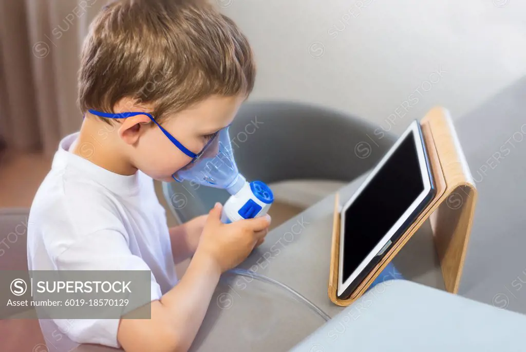 Nebulizer. The boy breathes through the mask.