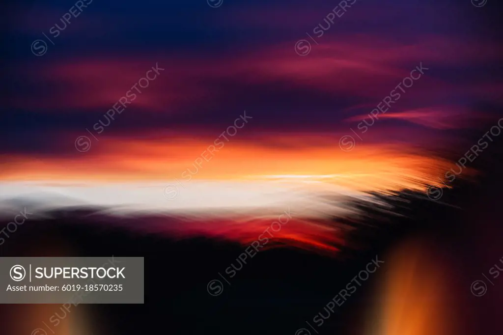 Warm and colorful creative and summery sunset over a forest