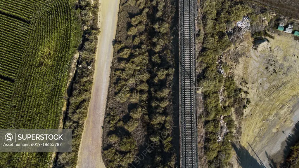 Aerial view of some train tracks next to a road