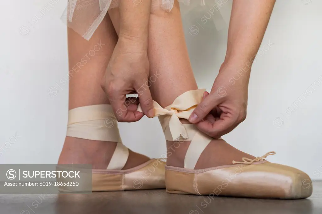 legs of girl dancing ballet with tulle skirt and pink shoes