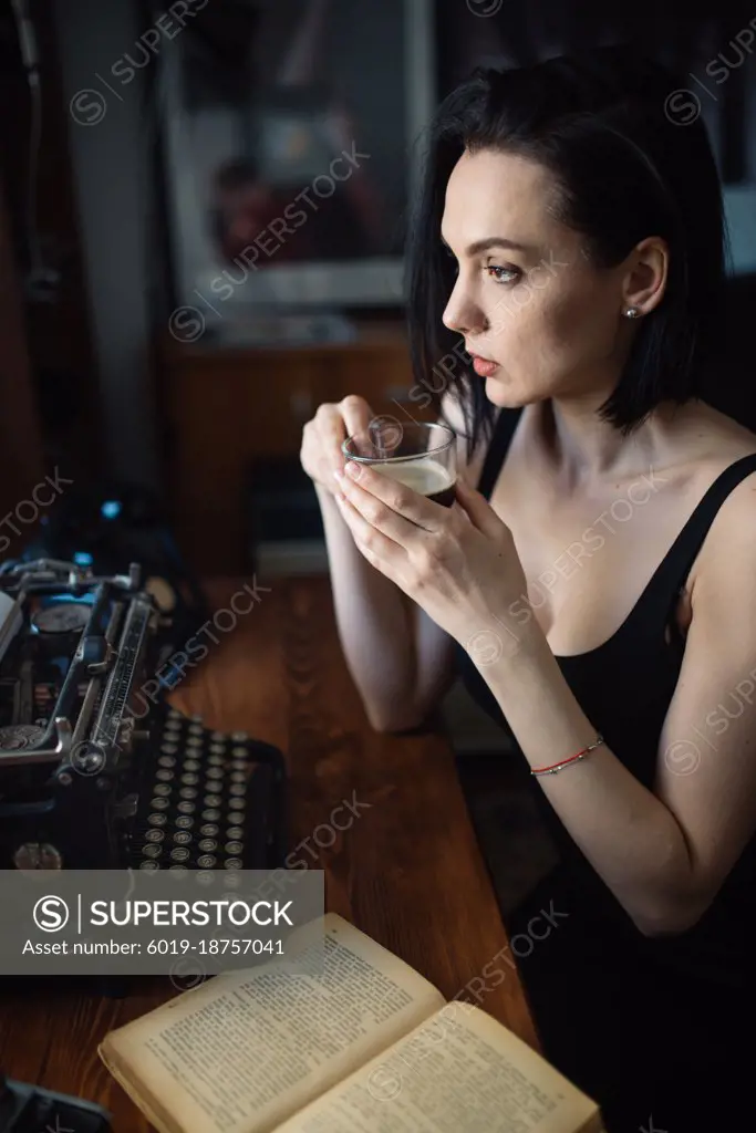 Female artist drinking coffee at home.