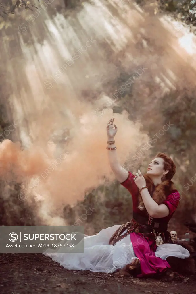 Witch with short hair in dress against the background of wild nature
