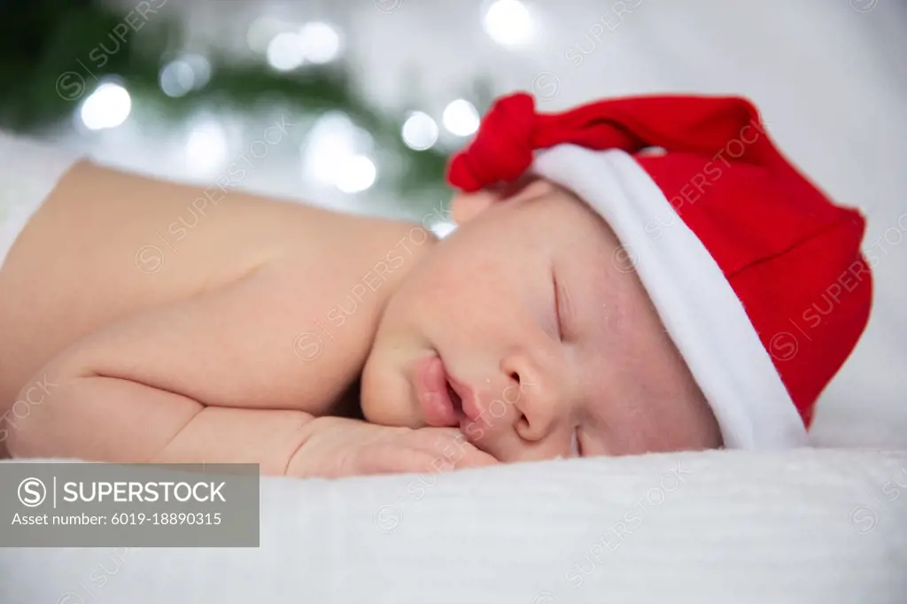 sleeping baby in santa claus cap