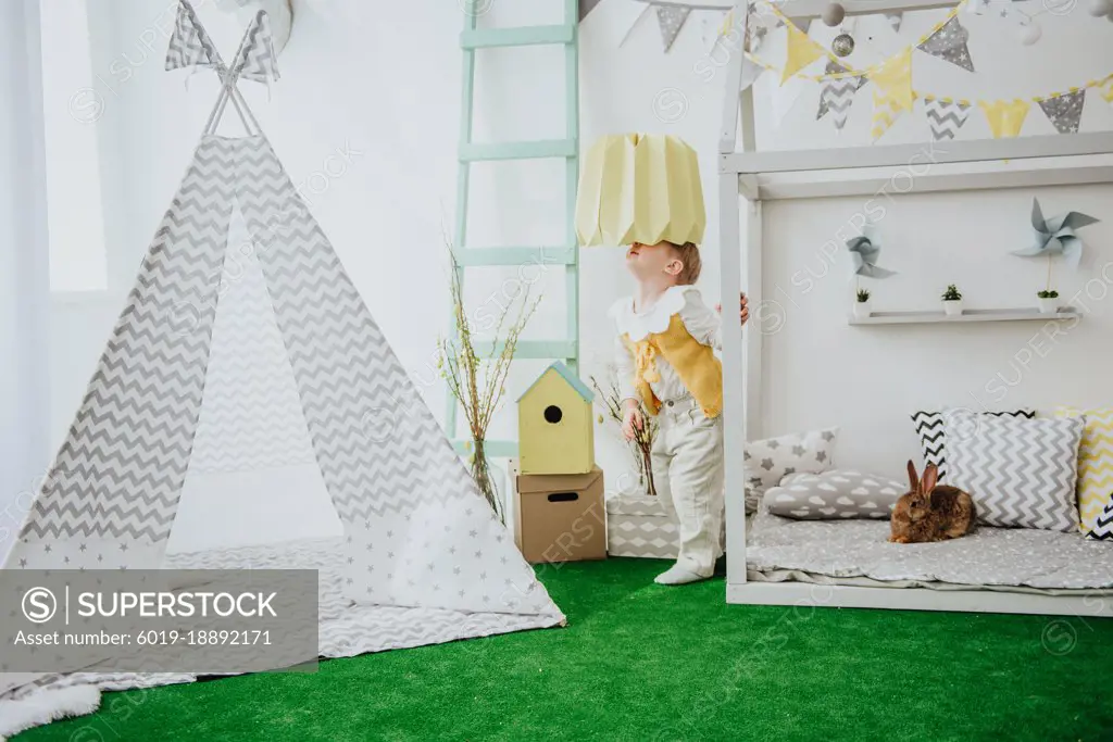 Little boy with bunny, posing at the Easter interior.