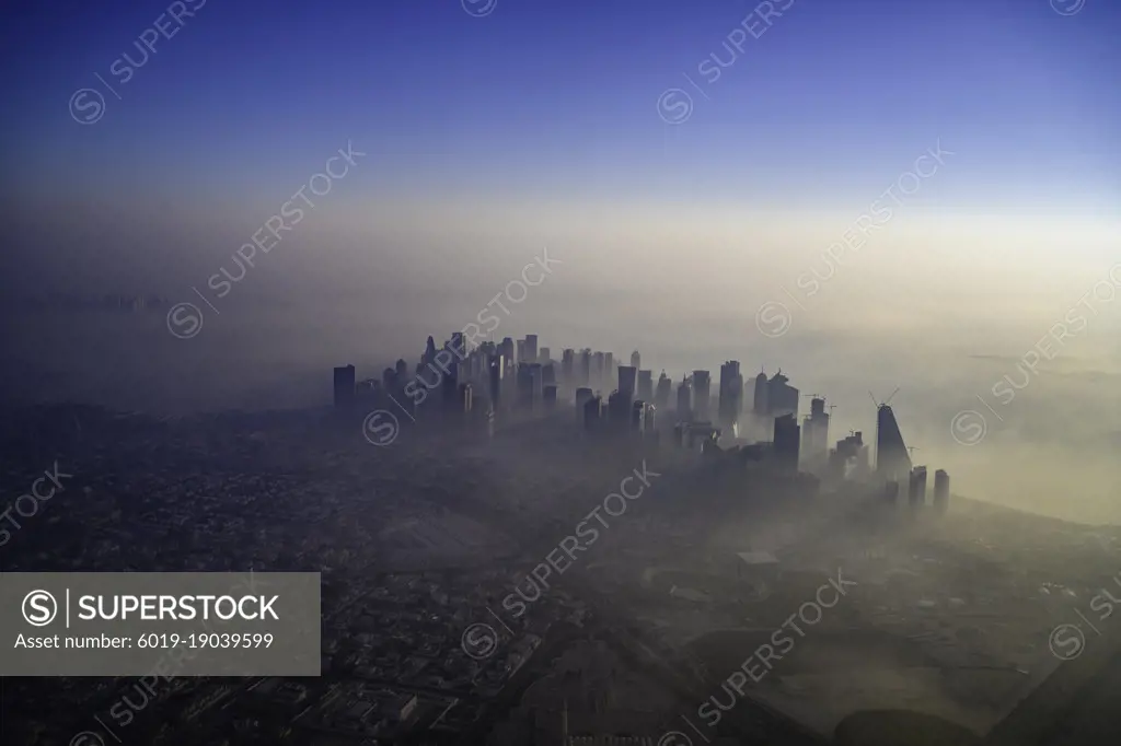 Doha skyline at sunrise with morning fog