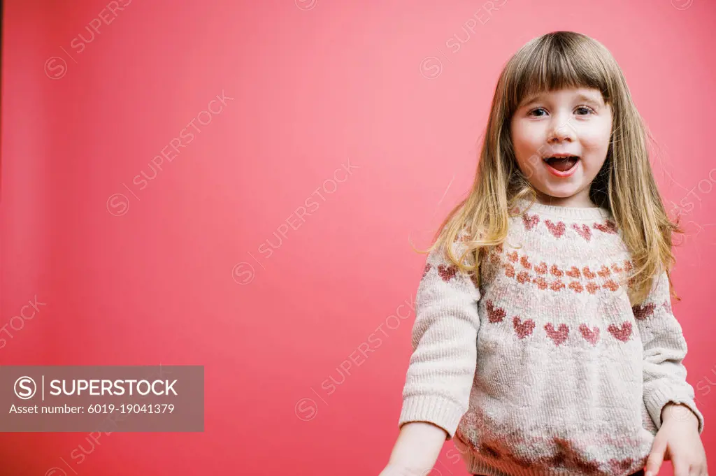 Little girl on a flamingo pink backdrop with copy space