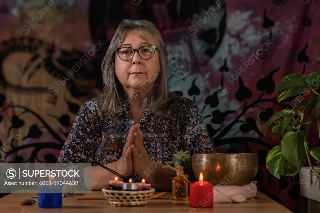 close-up of woman praying with candles and incense