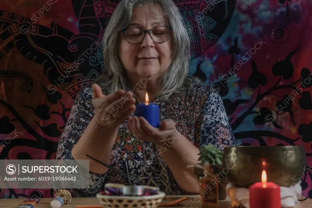 older woman looking at a lighted candle