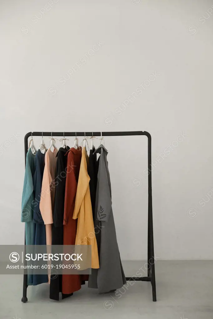 Black minimalistic rack with eco linen clothes on white backgrou