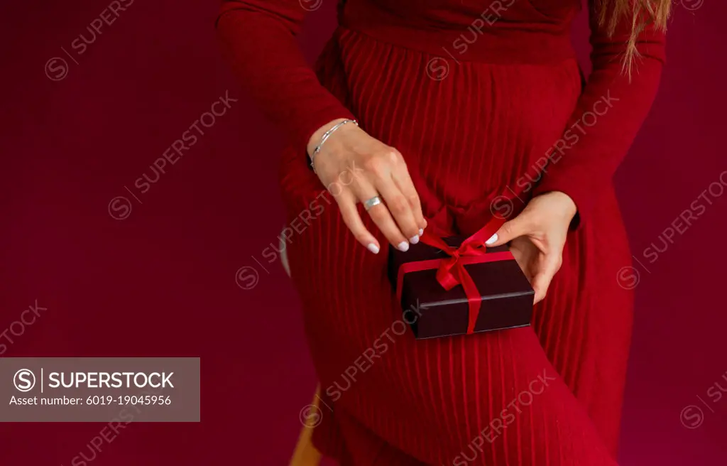 Close up of woman in red dress opened box with stripe