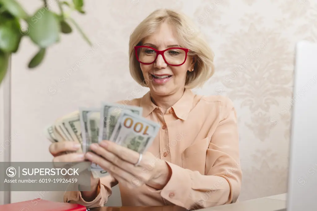 A woman with banknotes in her hands counts dollars money cash.
