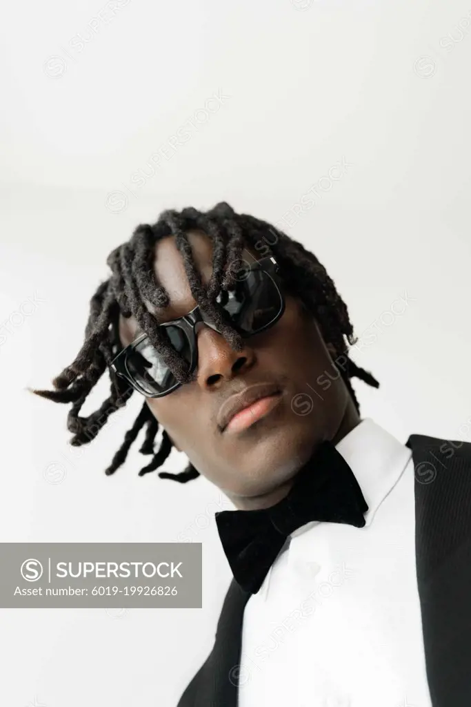 Portrait of the black man with dreadlocks wearing a suit with su