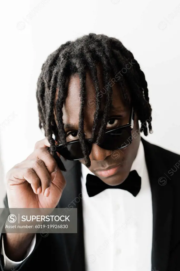 Portrait of the black man with dreadlocks wearing a suit with su