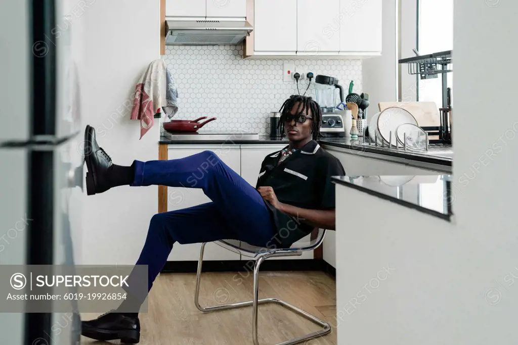 Black man with dreadlocks wearing vintage clothing sitting in th