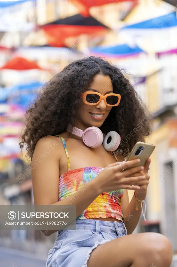 girl with afro hair using her smartphone