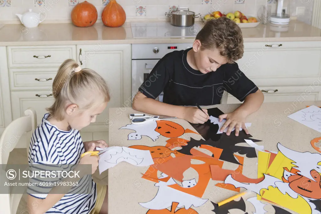 Children prepare decorations for the Halloween holiday, make crafts.
